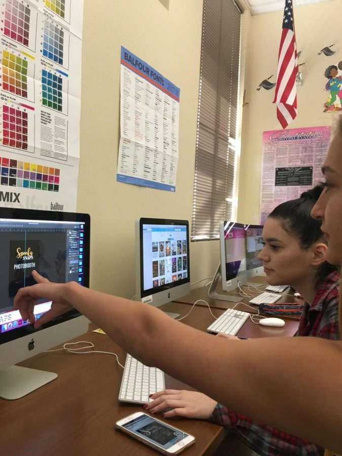 Yearbook members, Izabela Duarte and Nikki Nelson, work on making a flyer to advertise Spooky Snaps on October 19, 2017 in the yearbook classroom. The Spooky Snaps photo booth is an important fundraiser for raising money to improve the quality of this year’s yearbook. Photo by Kayla Wilson.