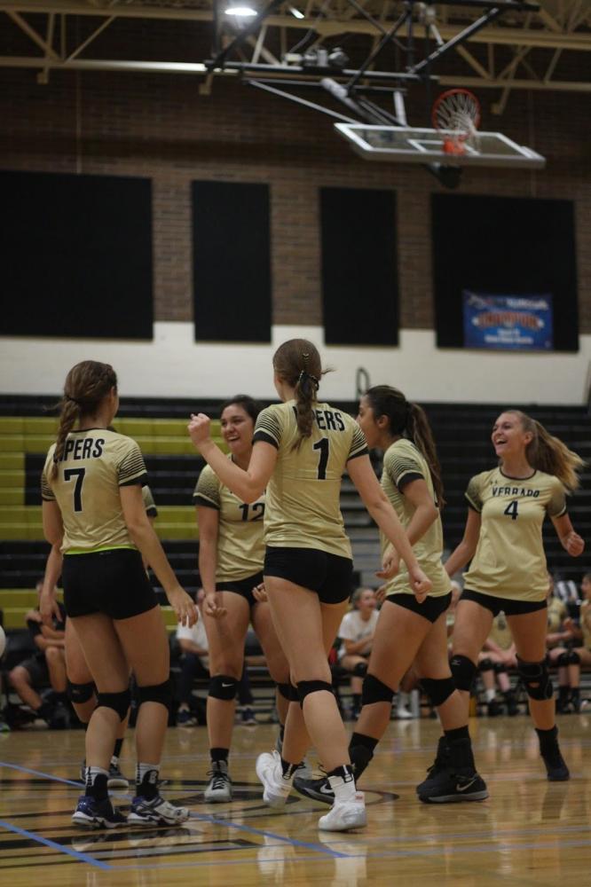 The varsity volleyball team celebrates scoring a point against Barry Goldwater High School at their home game on September 26, 2017. Their bond as a team has helped them to stay positive and strong as they play in tough conference games. Photo credit to Kayla Wilson.