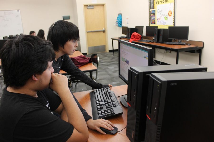 FBLA president, sophomore Marissa Macias teaches sophomore John Escobar how to code for the first time at the Hour of Code event held Wednesday December 6, 2017. Macias and her FBLA club sponsored the Hour of Code event to promote the importance of computer science in education and provide students with the opportunity to try coding. Photo credit to Krysyan Edler.