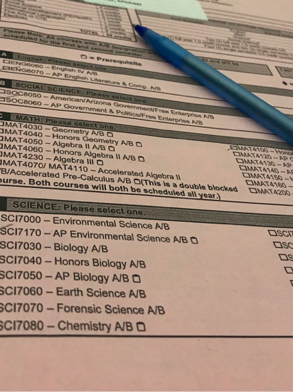 Junior Madeleine Lelito’s pink form for registration is almost fully filled out. The chosen classes are AP Environmental Science, AP English Literature and Composition, and AP Government. Photo credit to Jessica Quintana.