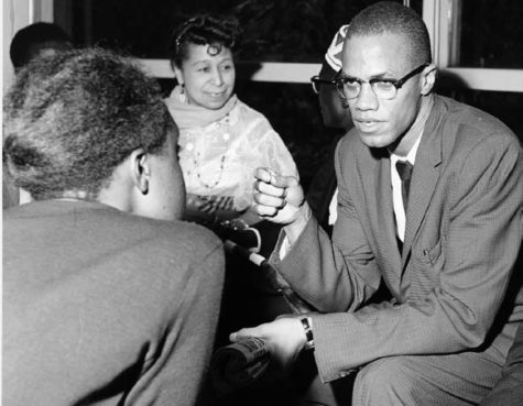 Malcolm X involved in a discussion with a group of women before 1963.