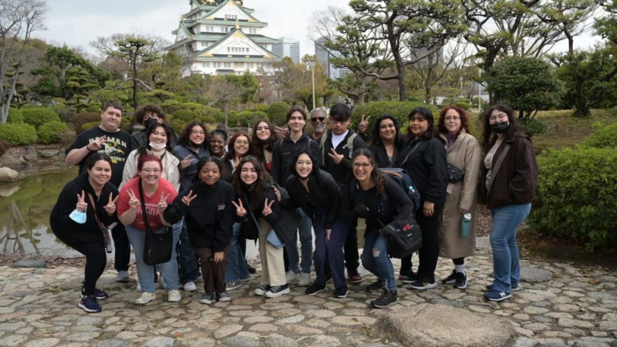 Students and sponsors pose in front of a Japanese garden during their trip. 
