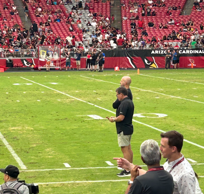 AZ Cardinals GM and owner assess the field during a preseason game.