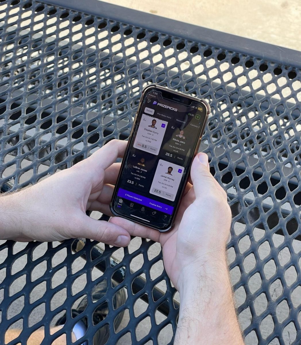 A student on their phone using the app PrizePicks, an app that is used to place sports bets.