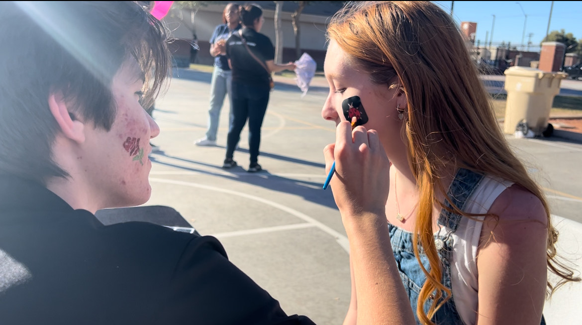 Verrado High School Senior, Caleb Balos face painting at the community art walk in Buckeye, AZ. His talents add a lively addition to the project.