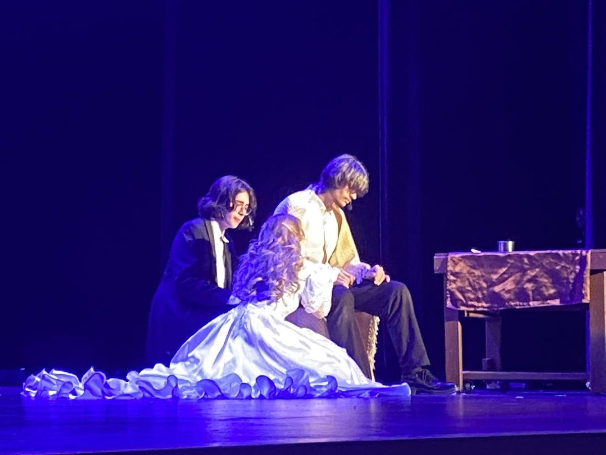 Cosette (Charlotte Wolter) and Marius (Ezra De Paz) comfort Jean Valjean (Michael Myers) in his last moments, shortly after their wedding.