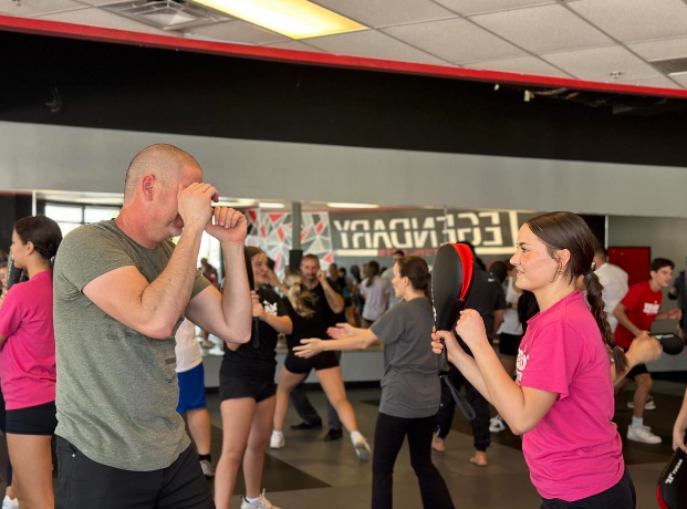 Alexis Morrison helps her father practice the new skill they learned by moving the pad around. Testing his hand-eye coordination and being quick on his feet.