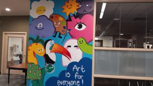 Student Darby Eyer and his group mural showcased in front of the art room, portraying their sentiment that art is a medium for everyone.