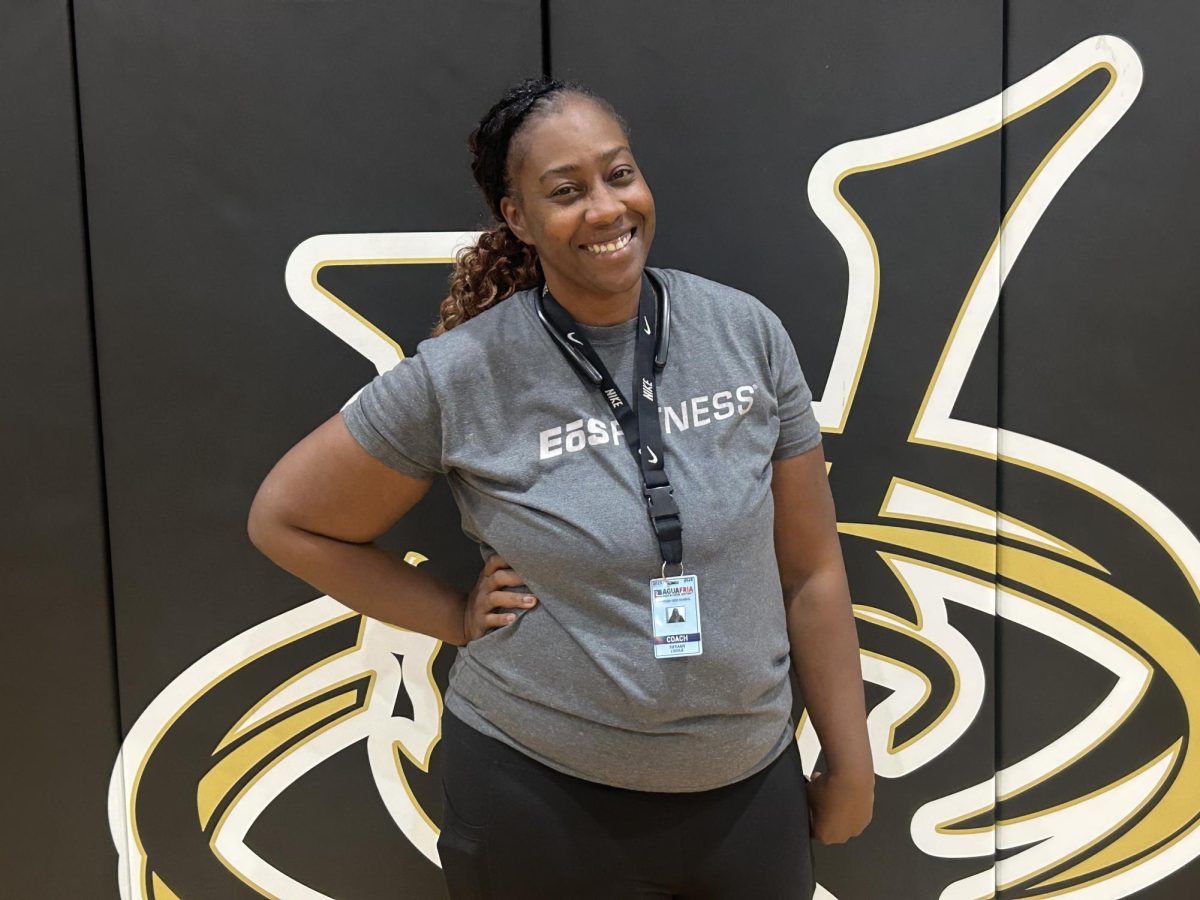 Coach Tiffany standing in-front of a vipers sign in the main gym.