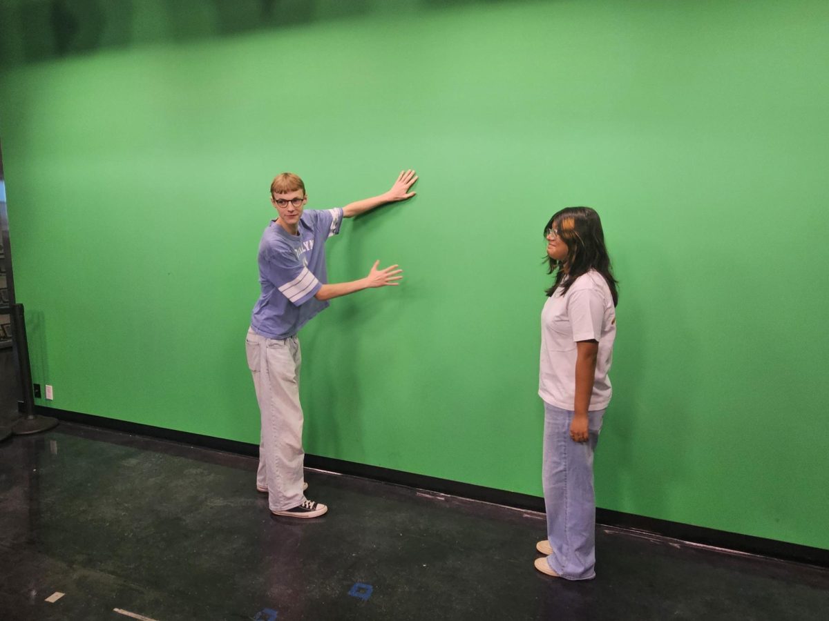 Kaden Craig and Amelie De La Torre pose in front of the green screen at the Walter Cronkite ASU campus