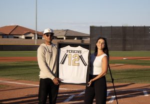 Blake Perkins and his wife holding up his jersey at the end of the ceremony.